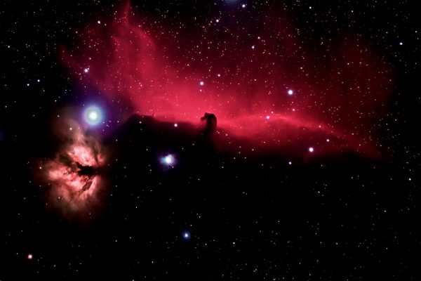 Nebulosa colorata nello spazio profondo con tonalità rosse e rosa e stelle sparse