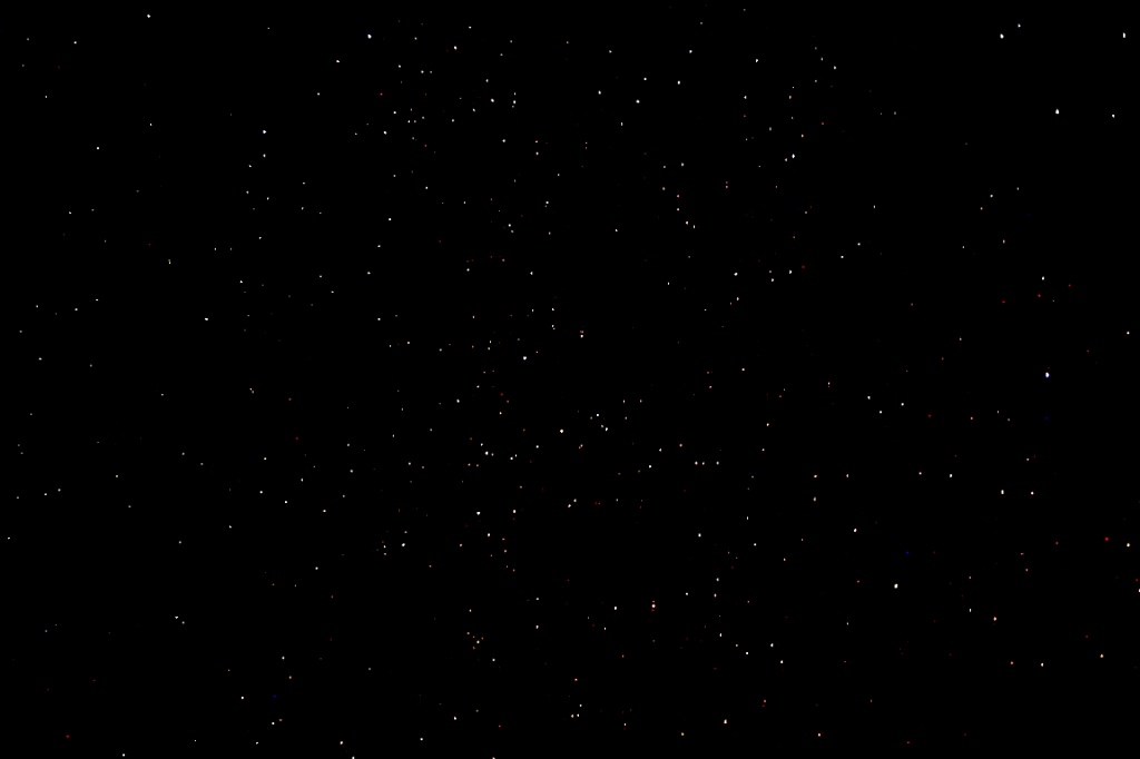 Cielo notturno nero punteggiato da deboli stelle bianche e colorate, atmosfera quieta
